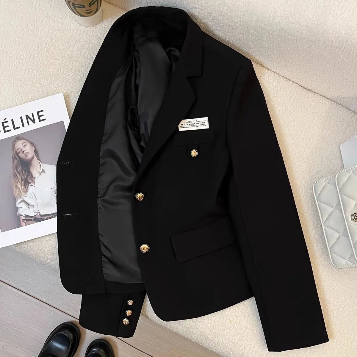 Black women's short suit coat with regular sleeves and pocket details