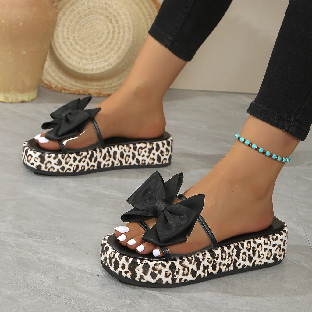 Leopard print women's beach slippers with thick sole and round toe in black colour.