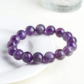 Natural feather amethyst crystal bracelet with geometric scattered beads and Ruyi design on a wrist.