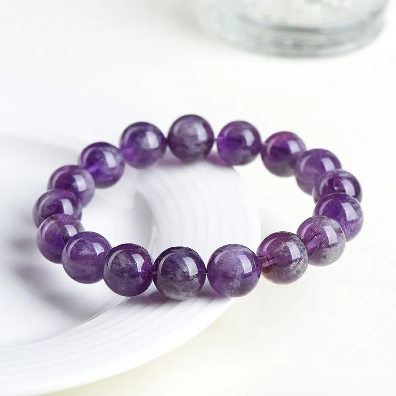 Natural feather amethyst crystal bracelet with geometric scattered beads and Ruyi design on a wrist.