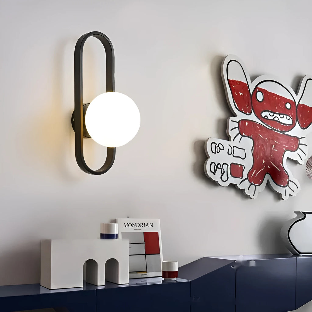 Minimalist modern wall lamp with glass shade and iron body in black finish, mounted on a wall.