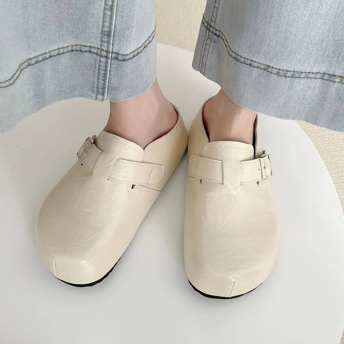 Flat buckle casual sneakers in yellow, creamy-white, silver, and black colours on a white background.