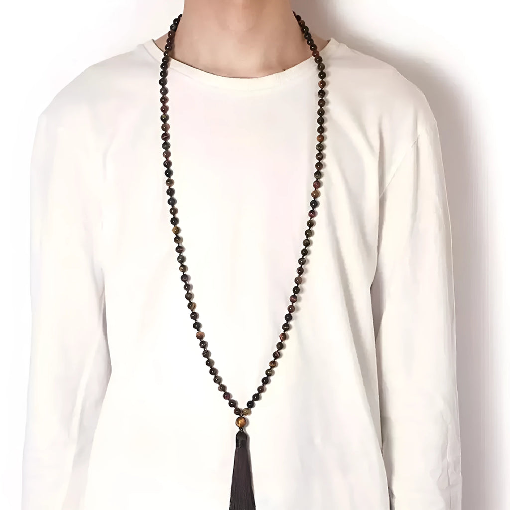 Long blue patterned agate and stone tassel necklace with geometric beads on a white background.