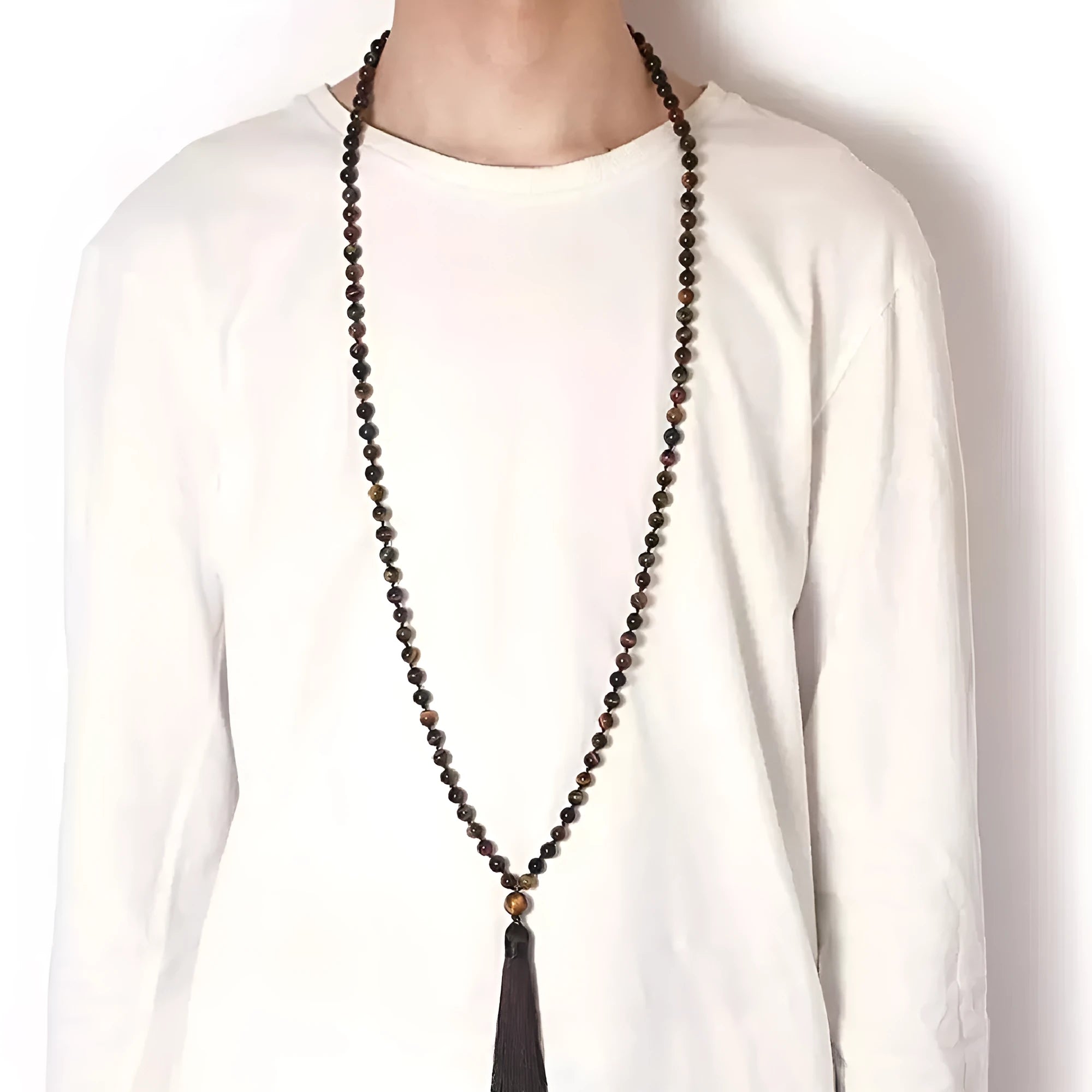 Long blue patterned agate and stone tassel necklace with geometric beads on a white background.