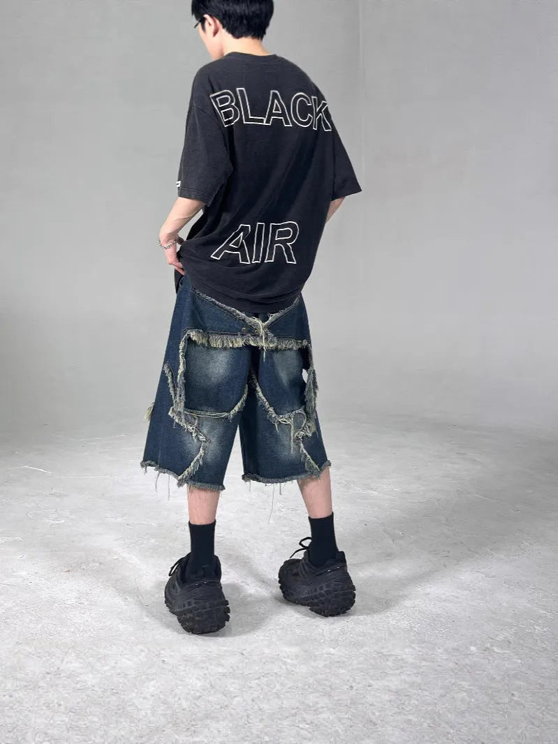 Men's blue retro denim shorts with a frayed five-pointed star design on the leg, showing loose fit.