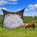 Black woven PE rope horse feeding bag with grid design hanging in stable