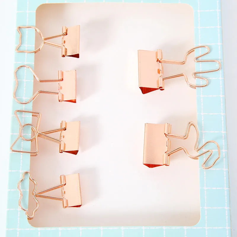 Gold plated decorative paper clip in a choice of flamingo, love, cloud, cat, cactus, or bow designs on a white background.