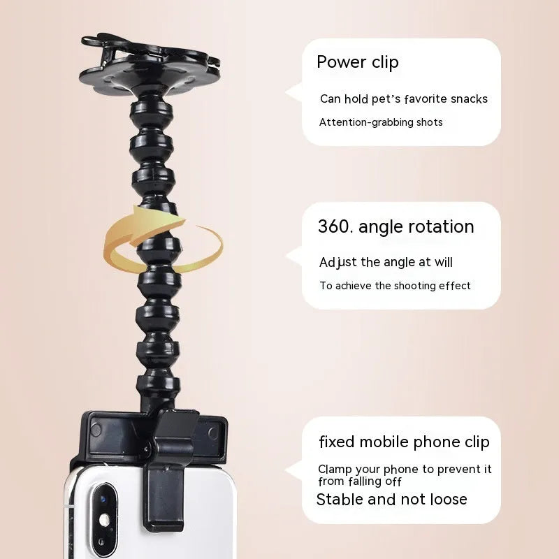 Black plastic pet photography tool with treat clip and phone holder, shown rotated to adjust angle.