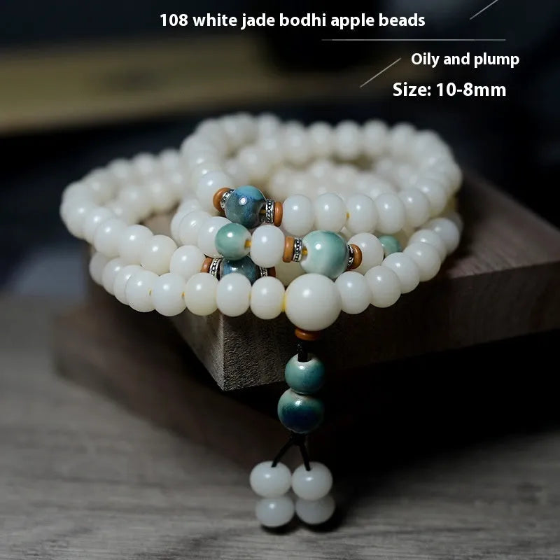 White jade bodhi seed bracelet with 108 flat round beads on a wrist.