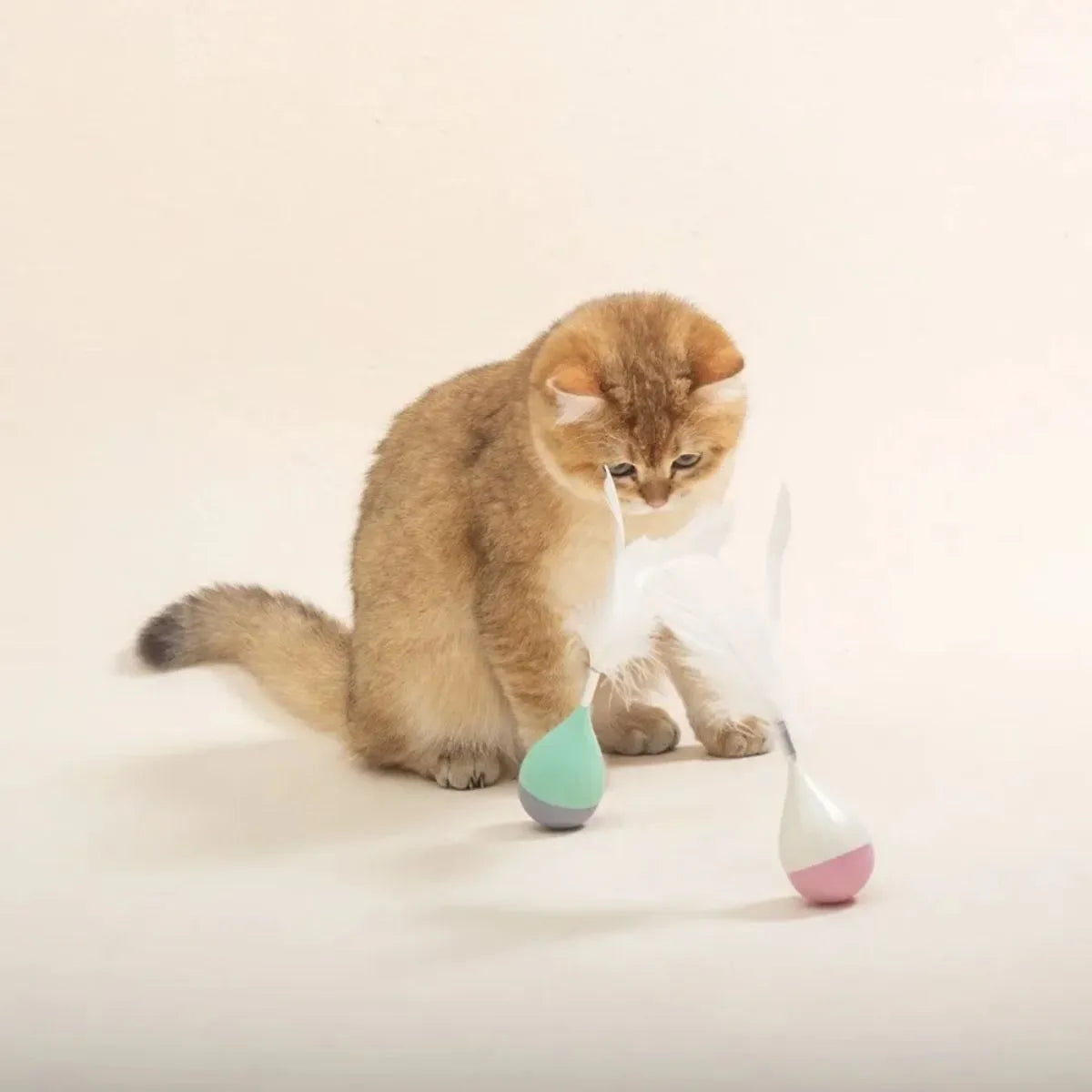 Green and pink feather tumbler cat toy with self-healing design