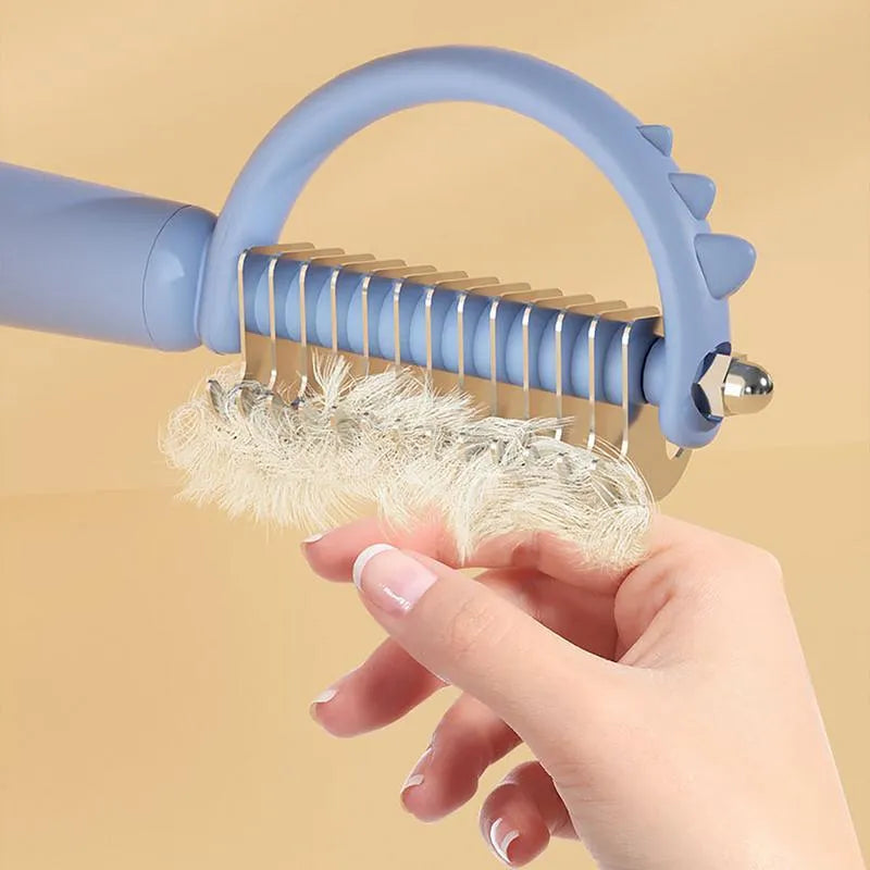 Blue dinosaur-shaped cat brush with double-sided grooming heads for shedding and dematting