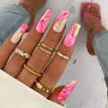 Wearable manicure set with 24 medium nails in rose, tulip, leopard print, and XINGX designs, plus glue.