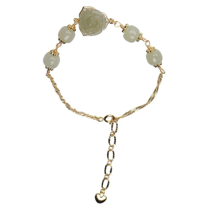 Original design women's bracelet with a Hetian Jade rose and 14K gilded details on a wrist.