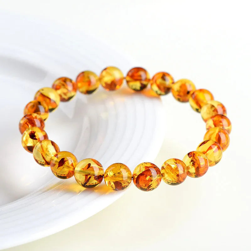 Natural yellow piebald amber bracelet with polished geometric beads on a wrist.