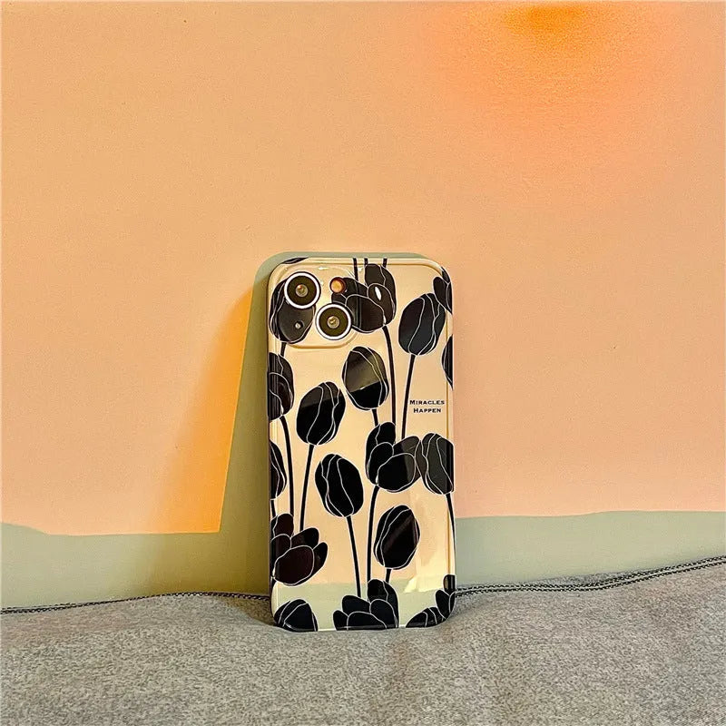 Black silicone iPhone case featuring a printed tulip flower design on the back.