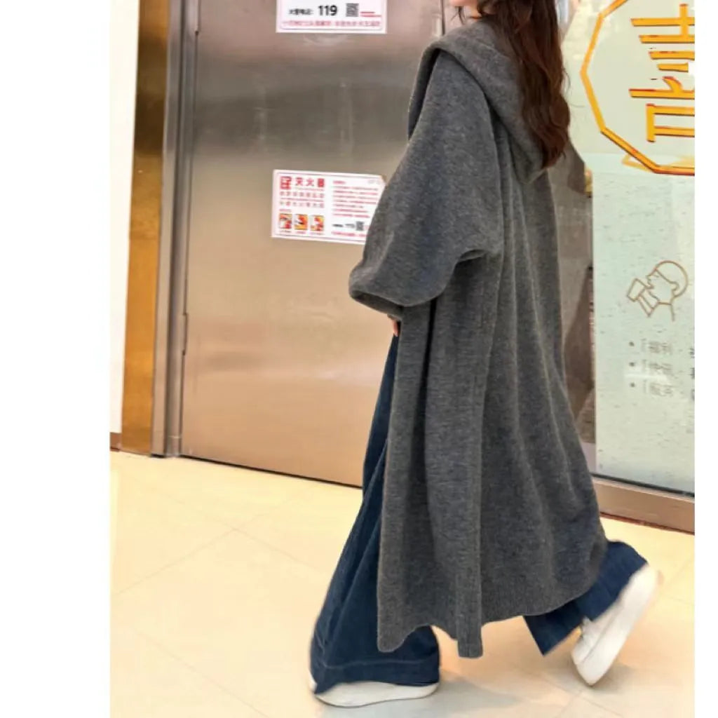 Women's long brown knitted hooded cardigan with a loose fit and below-the-knee length.
