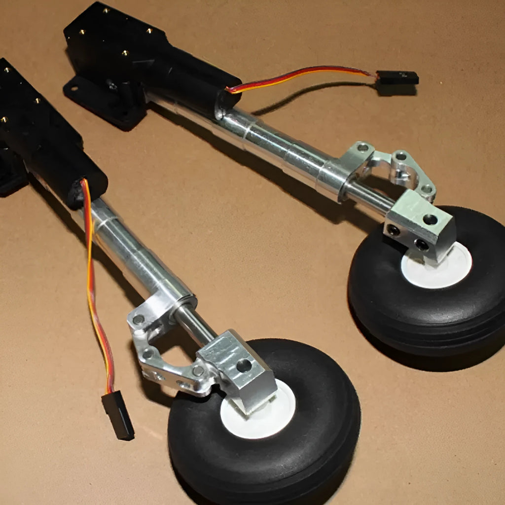 Pair of silver alloy retractable landing gear with shock absorbers and black rubber wheels for RC model aircraft.