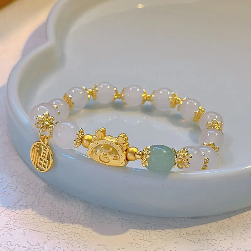 Glass and coloured glaze bracelet with animal zodiac charm and electroplated finish in red, pink, or white pearl.