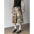 Women's yellow snake pattern camouflage print cropped denim jeans laid flat.