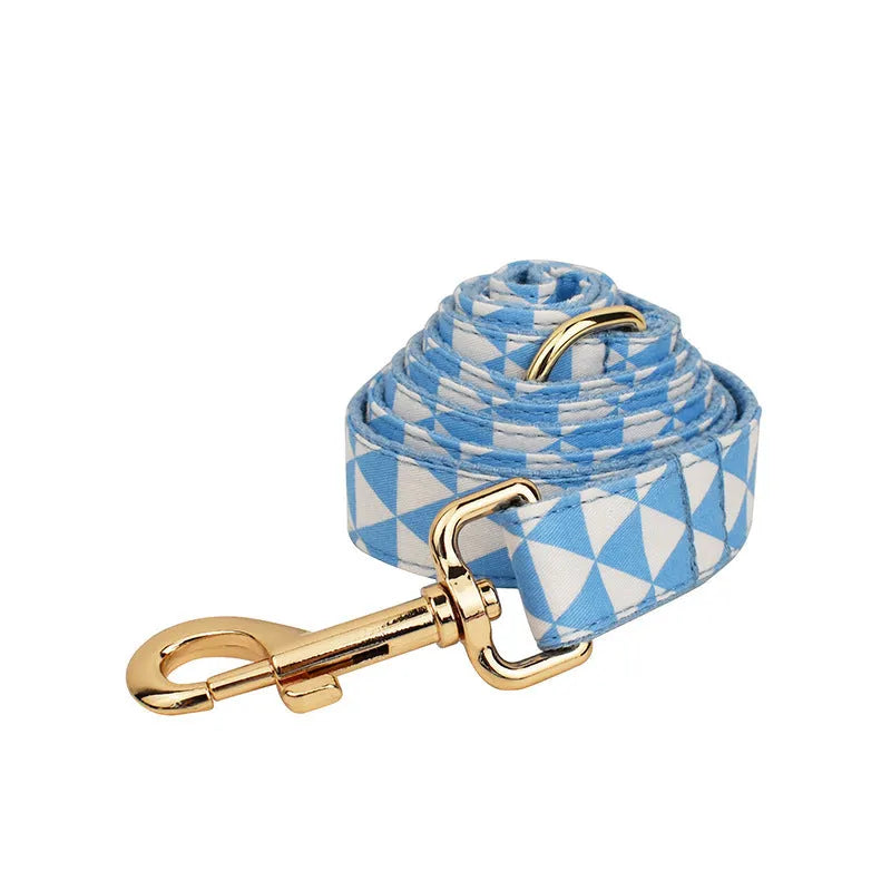 Blue cloth dog collar, leash, vest, and bow set arranged together showing all four pieces.