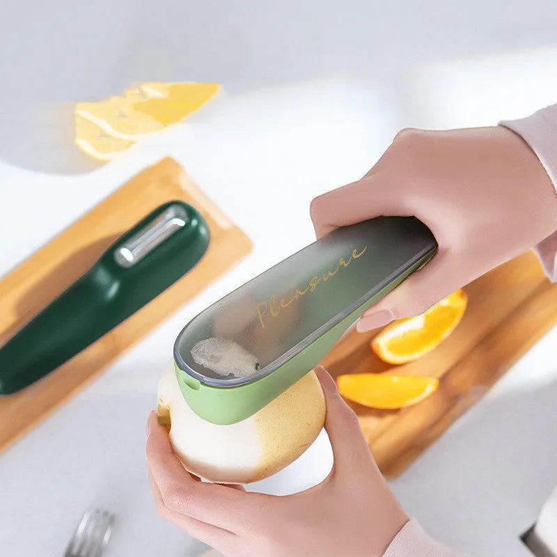 Dark green fruit vegetable peeler with storage tube showing stainless steel blade and hanging hole