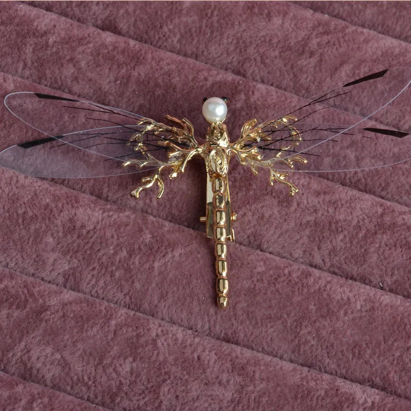 Gold-coloured dragonfly headdress with side clip fastening and floral decorative elements