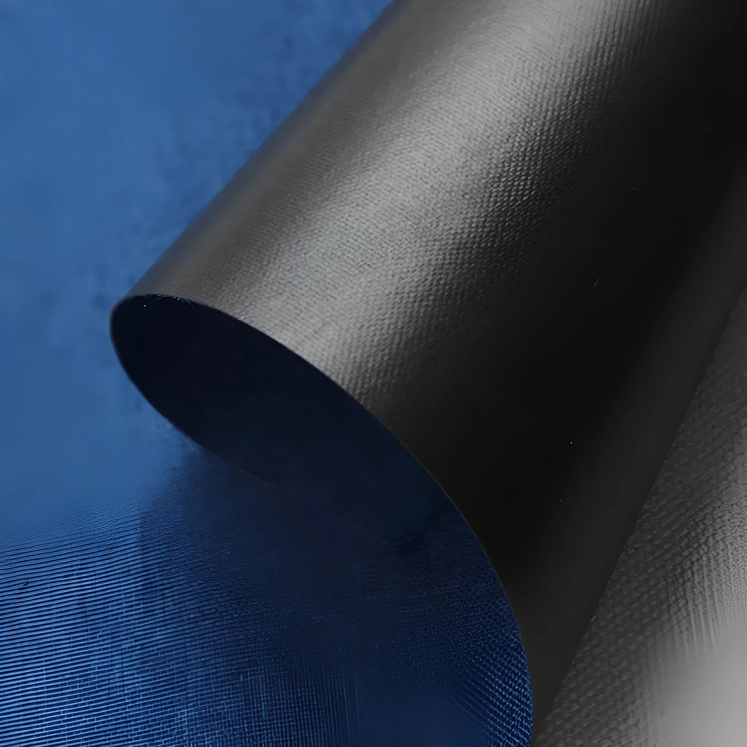 Black, blue, and green swatches of polyester Ant Cloth fabric on a roll.