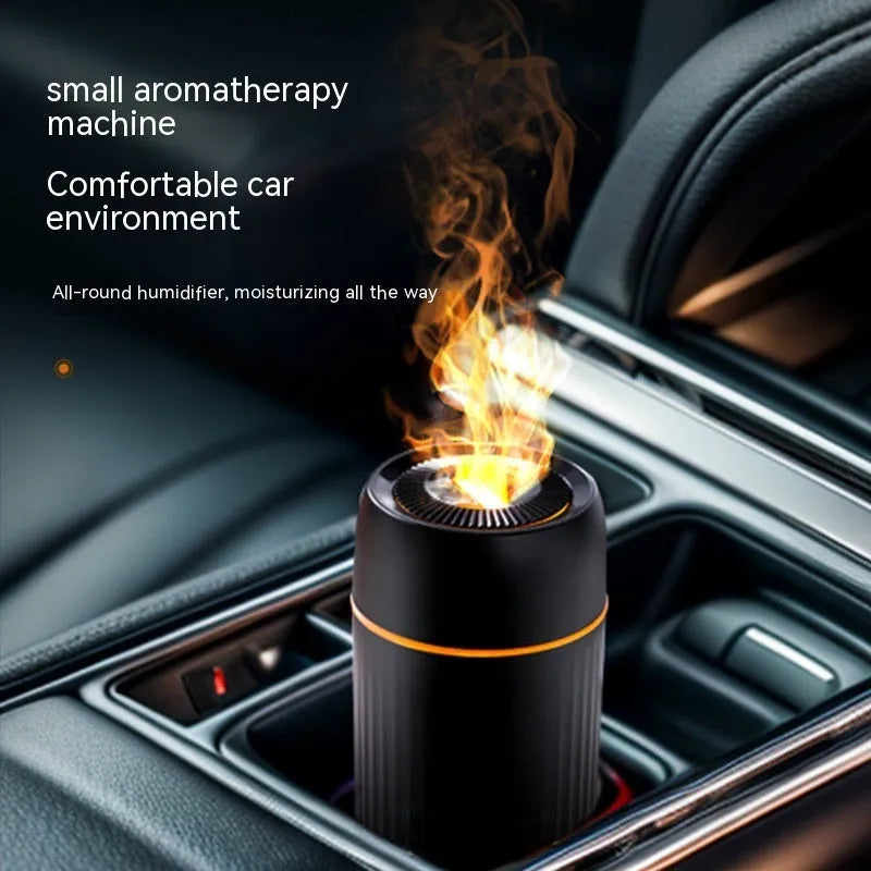 Black car aroma diffuser with simulation flame on a dashboard next to a cup holder.