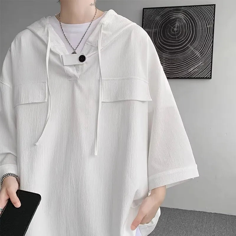 Man wearing a loose black hooded short sleeve t-shirt, a summer casual pullover top.