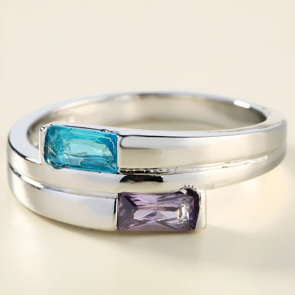 Copper ring with inlaid zircon stone in electroplated silver finish on a grey background.