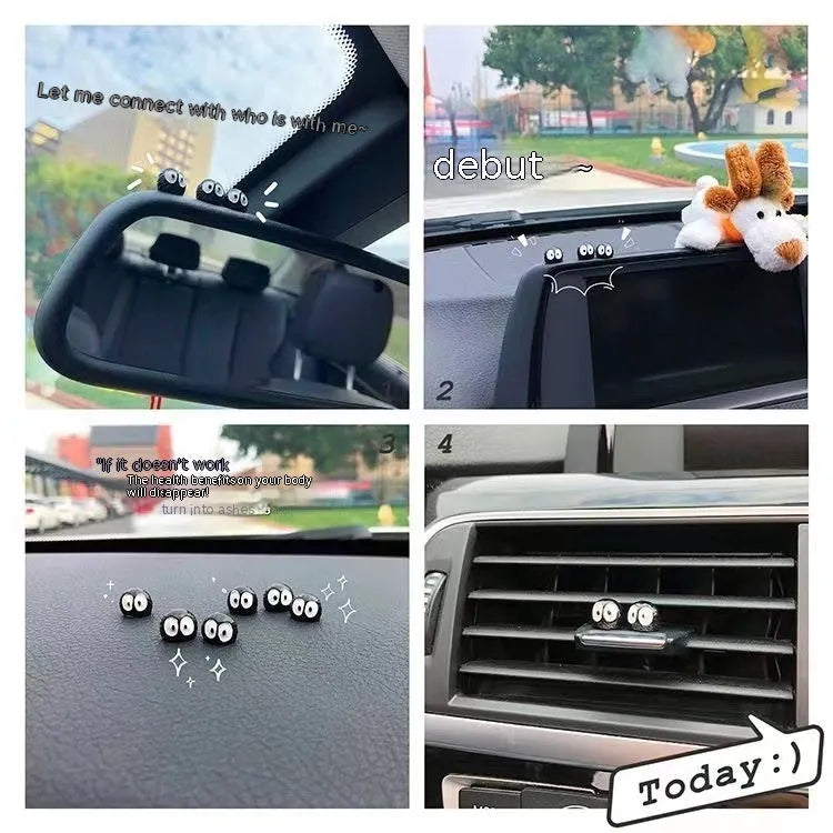 Small black resin coal ball cartoon decoration on a car dashboard.