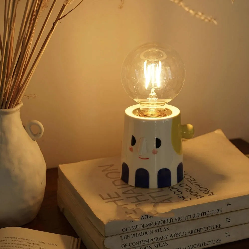 Handmade ceramic table lamp with ball-shaped shade on wooden surface
