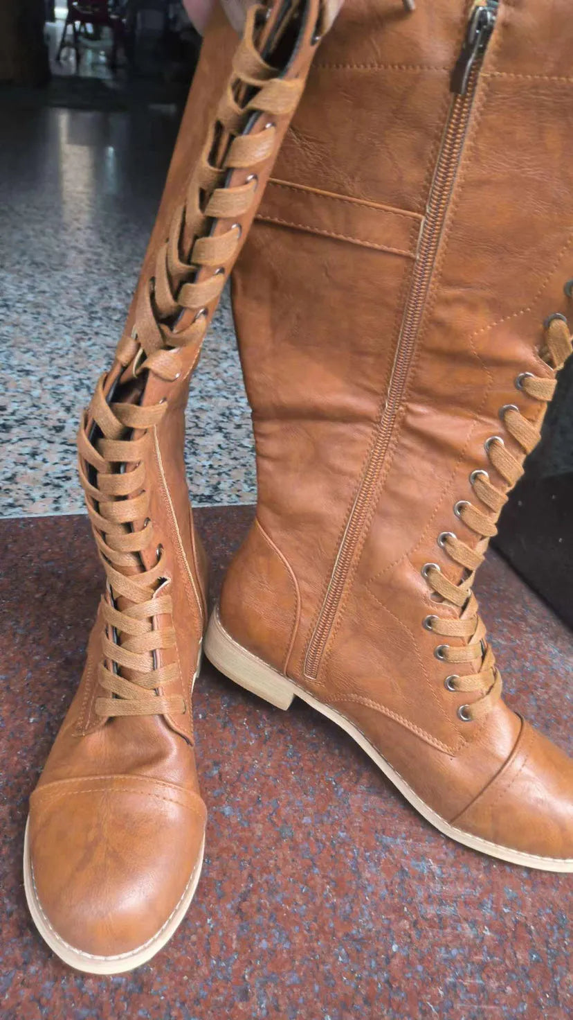 Women's black knight ankle boots with a cross strap detail on the front.