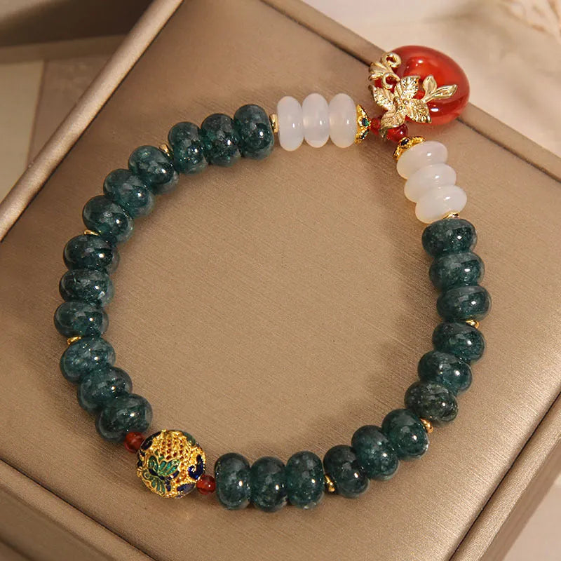Women's blue water jade and red agate bracelet with peace buckle closure and rhinestone details
