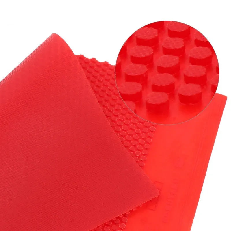 A single sheet of raw table tennis rubber in black or red colour with a small-particle texture surface.
