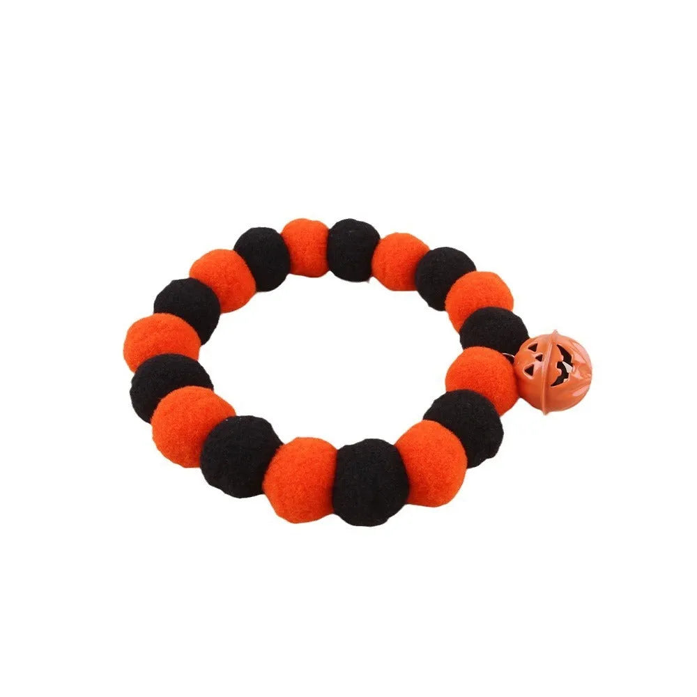 Black, orange, green, and purple Halloween pumpkin cat collar with adjustable strap.