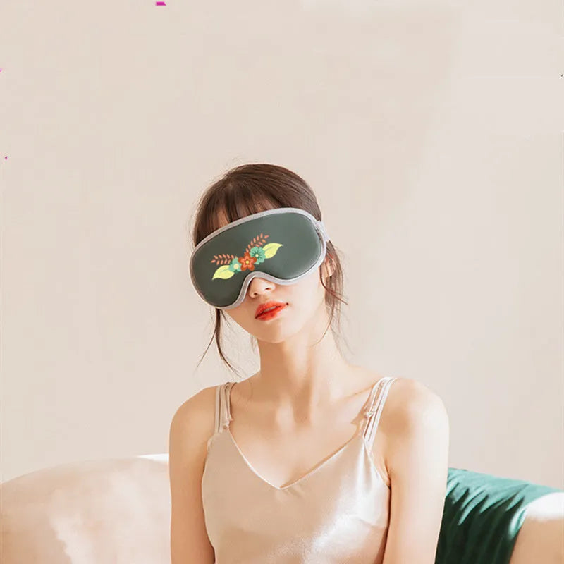 Green portable eye SPA mask with USB cable on a grey background