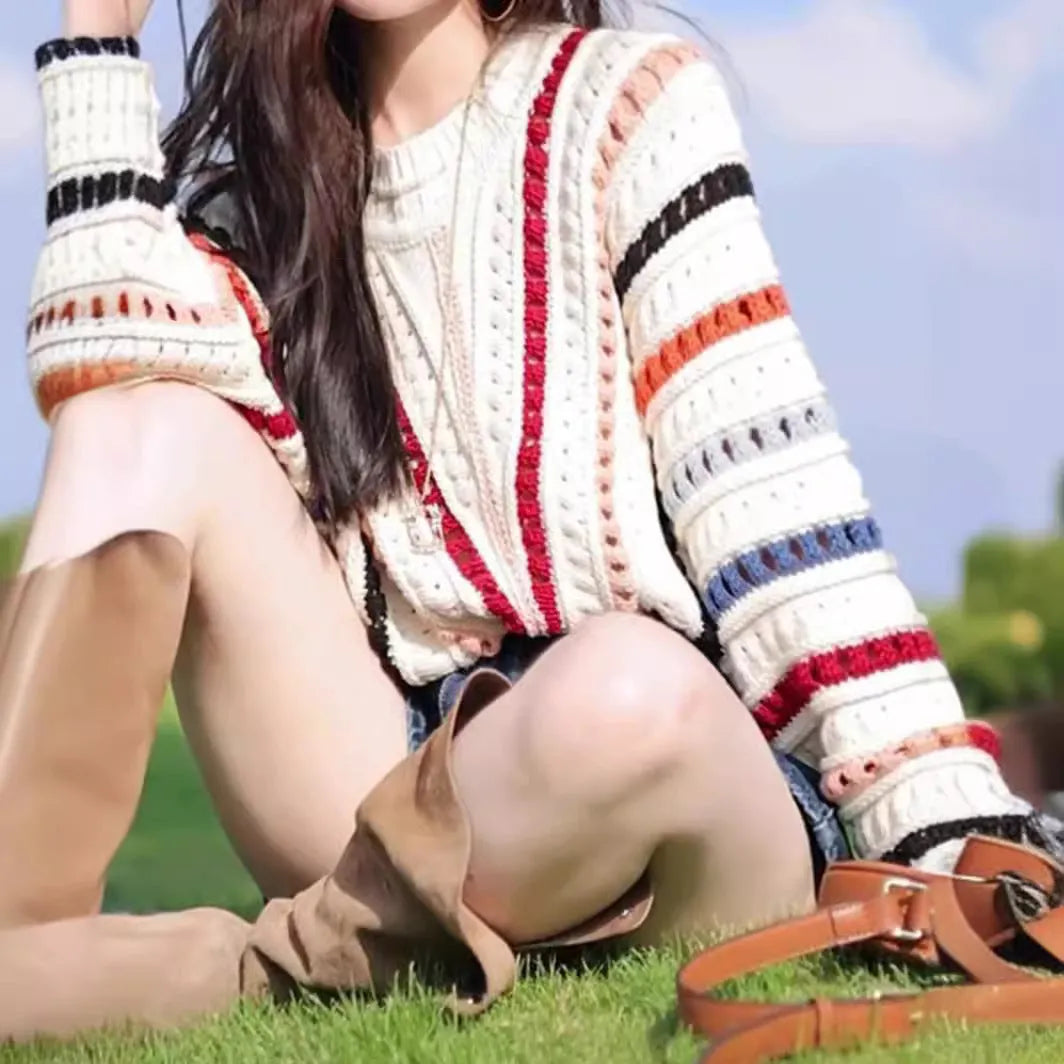 Round neck pullover sweater with rainbow stripes in hollow knit design featuring batwing sleeves