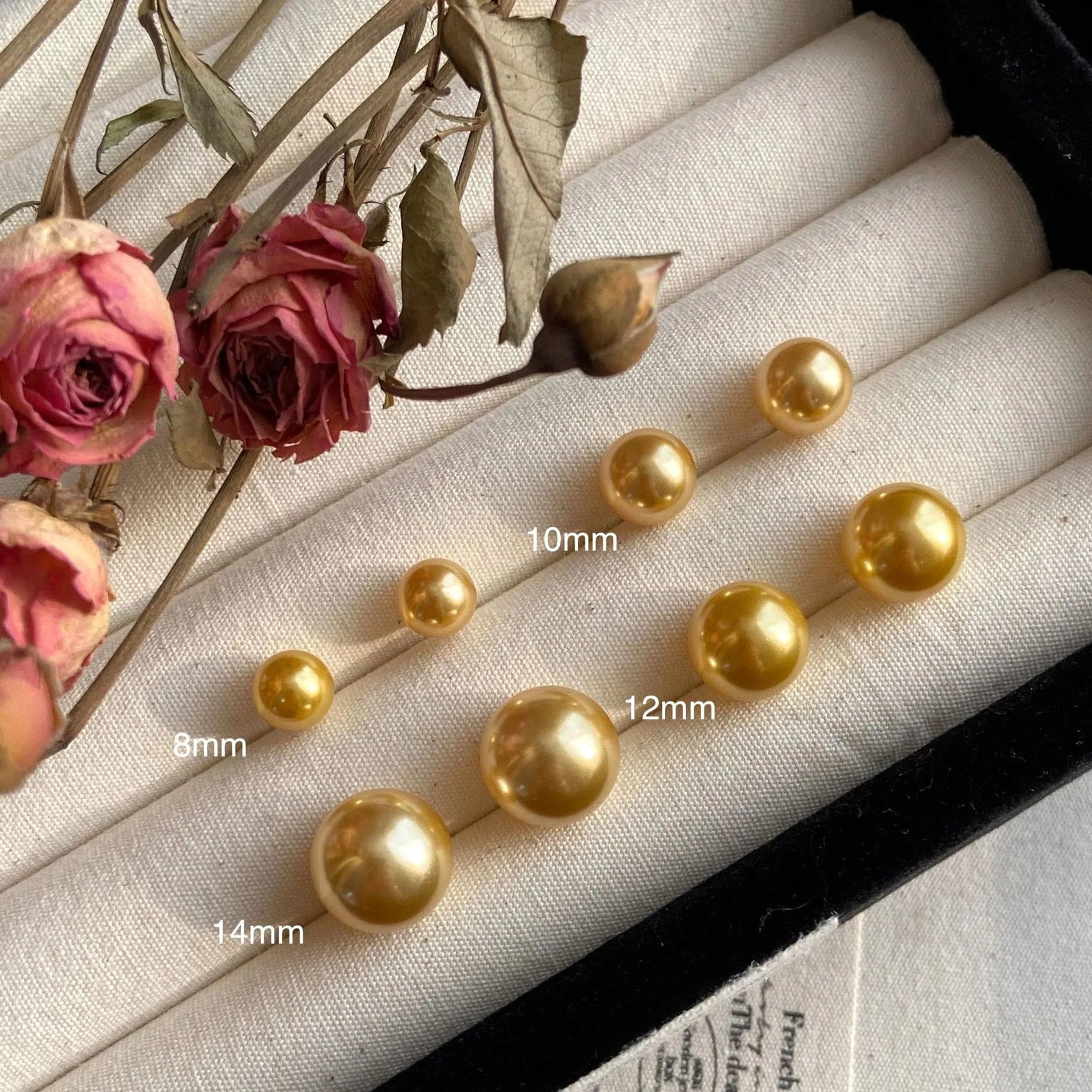 A pair of large pearl stud earrings with a geometric silver setting and an eight-awh star detail on a white background.