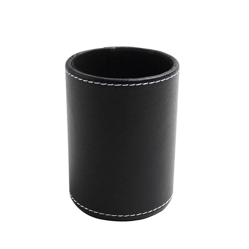 Small round black leather pen holder container on a desk