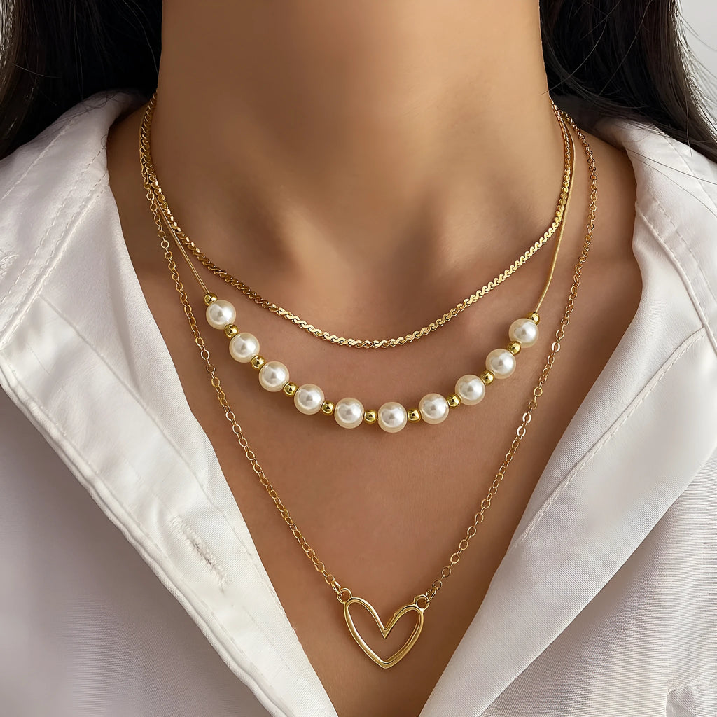 Vintage gold necklace with love heart pendant on a pearl chain, adjustable length.