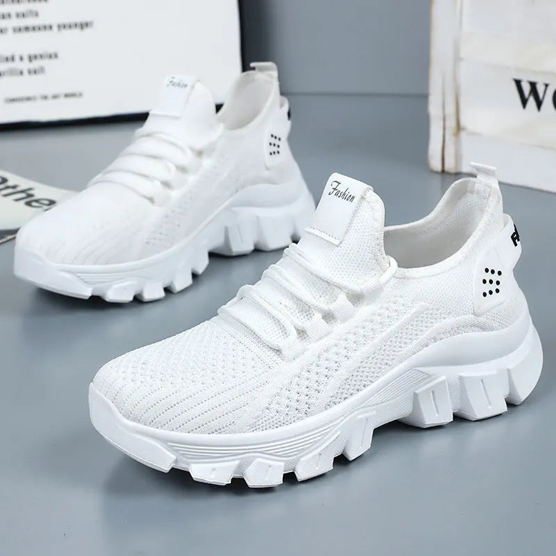 Women's white Flyknit sneaker with thick PVC sole and lace-up closure on a neutral background.