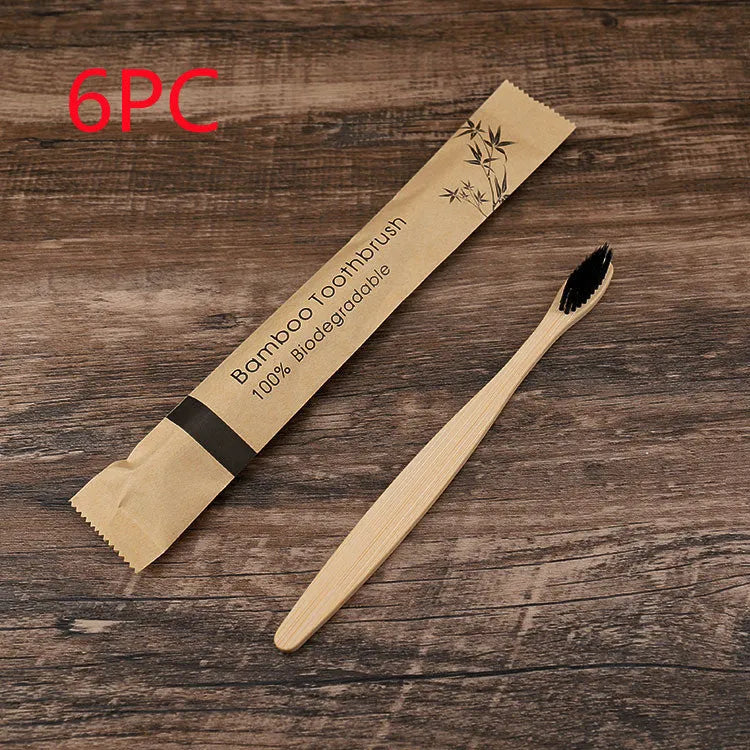 Ten bamboo toothbrushes with coloured handles and charcoal bristles laid out side by side.