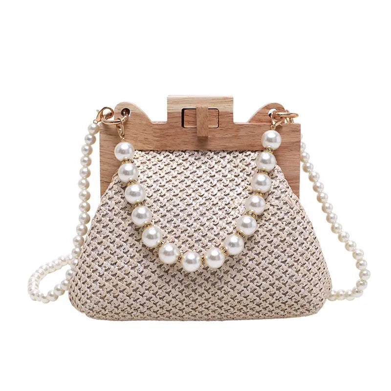 Women's straw woven shoulder bag with pearl chain trim showing internal compartments