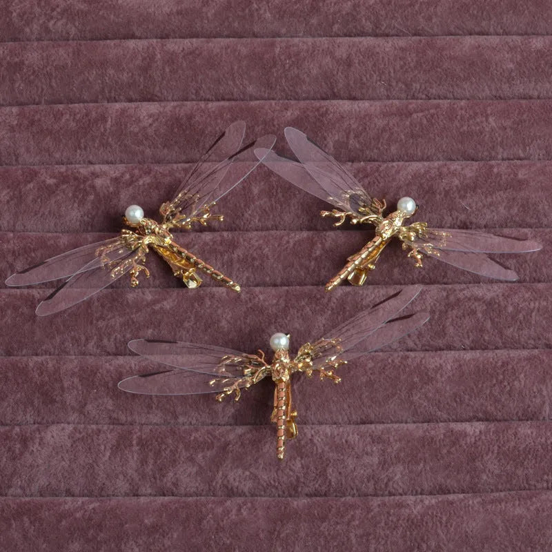 Gold-coloured dragonfly headdress with side clip fastening and floral decorative elements