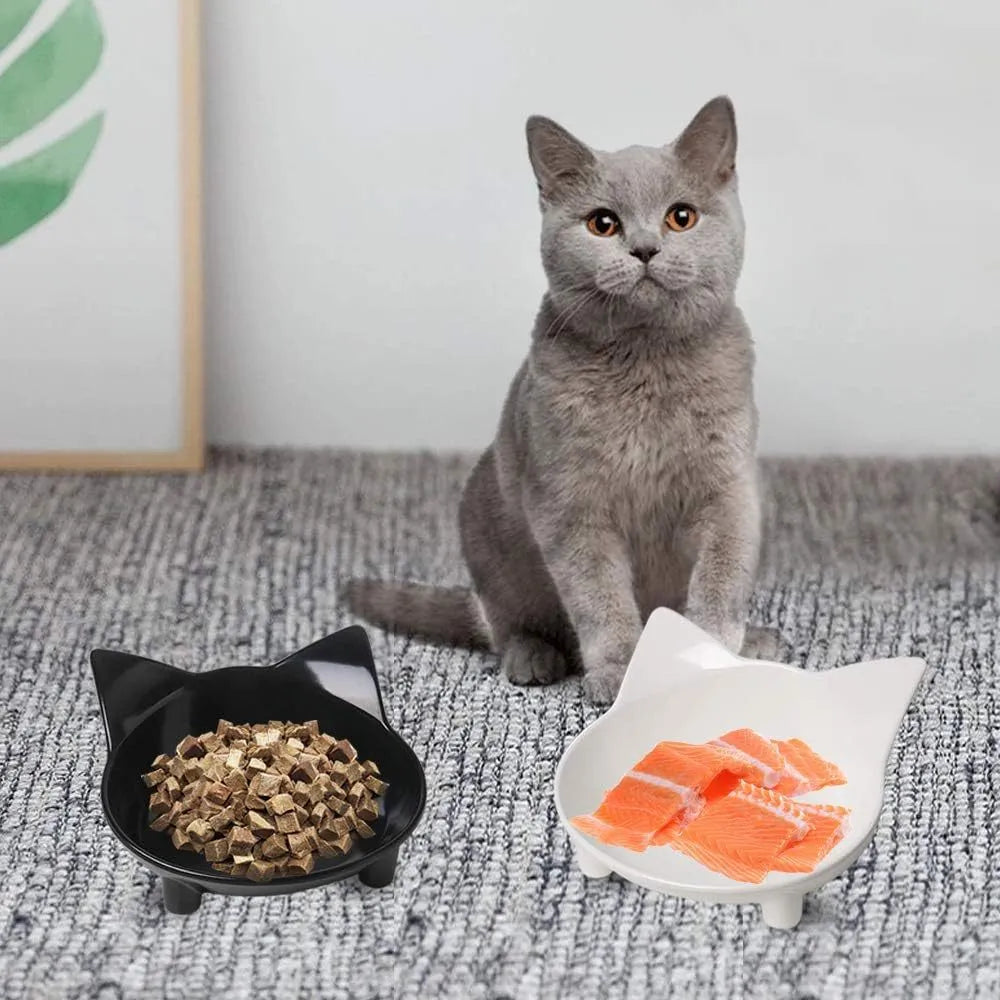 Shallow black melamine pet bowl with a non-slip rubber base on a kitchen floor.