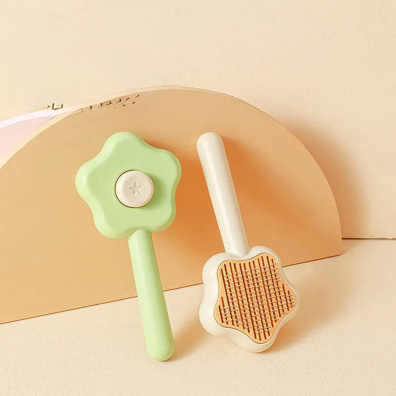 Green stainless steel cat comb with magic wand self-cleaning mechanism showing needle teeth and plastic handle