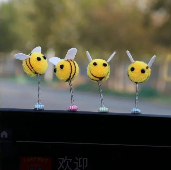 Small plush swing spring bee car decoration ornament on a 3cm scale grid.