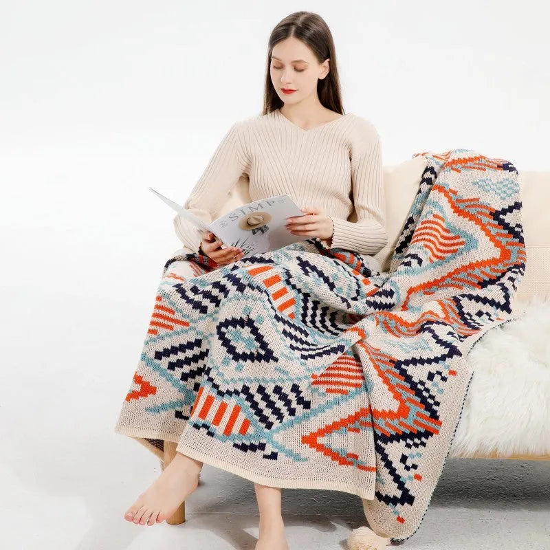 Acrylic sofa blanket with tassel fringe in neutral beige tone on grey sofa