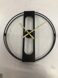 A large 50 cm round metal wall clock on a wall, available in black or gold finish.